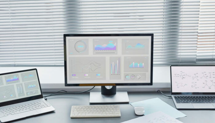 Close-up of computer with big monitor with charts on the screen standing on the table in the lab